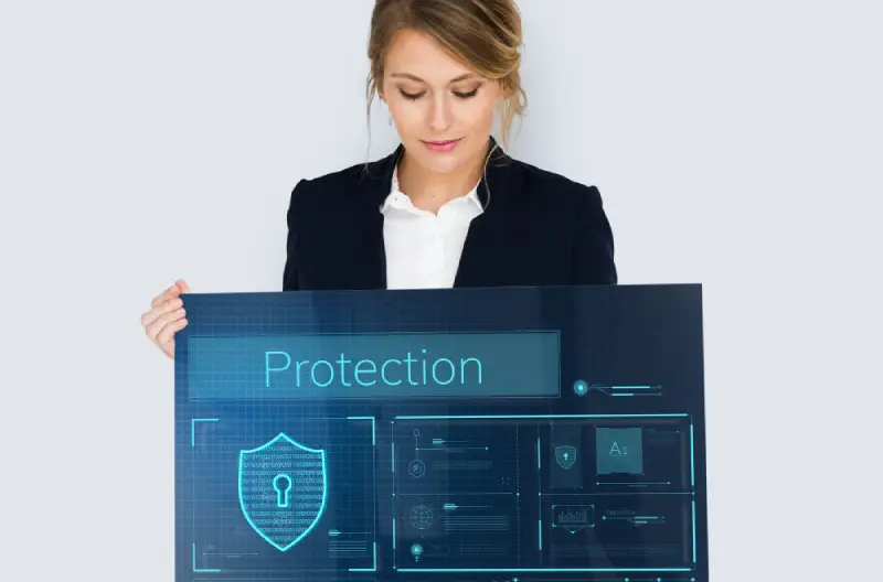 Migrinfo - Anticiper les cybermenaces Femme tenant un grand écran avec écrit protection pour illustrer l’anticipation des risques